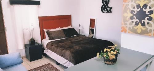 a bedroom with a bed and flowers on a table at Salón y habitaciones 783 in Rosarito Beach