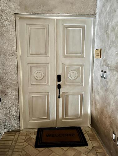 a white door with a welcome mat in front of it at Val'quirico Auguri Zócalo II, Depto 5 Camas in Santeagueda