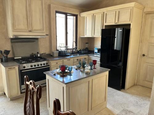 a kitchen with white cabinets and a black refrigerator at Val'quirico Auguri Zócalo II, Depto 5 Camas in Santeagueda