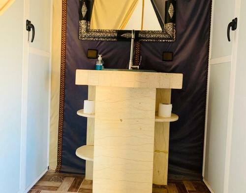 a bathroom with a sink and a mirror at Magic Carpet camp in Merzouga
