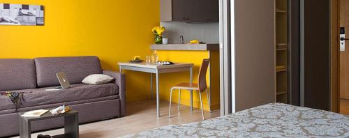 un salon avec un canapé et une cuisine dans l'établissement Adagio Paris Parc Expo Appart hotel, à Issy-les-Moulineaux