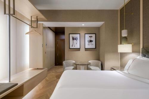 a bedroom with a bed and a table and chairs at AC Hotel Firenze by Marriott in Florence