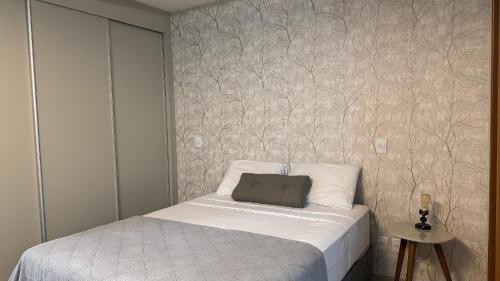 a small bedroom with a bed and a wall at Monte Carmel in Ribeirão Preto
