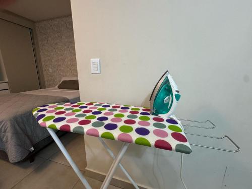 a polka dot chair sitting next to a bedroom at Monte Carmel in Ribeirão Preto
