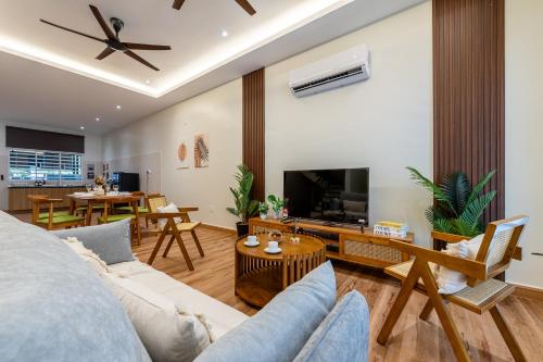 a living room with a couch and a tv at La Ferringhi Villa - Balinese Collection, by ALV in Batu Ferringhi