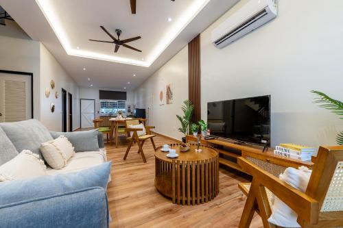 a living room with a couch and a tv at La Ferringhi Villa - Balinese Collection, by ALV in Batu Ferringhi