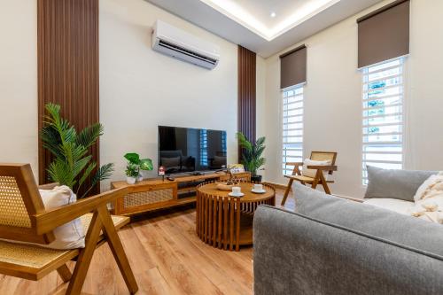 a living room with a couch and a tv at La Ferringhi Villa - Balinese Collection, by ALV in Batu Ferringhi