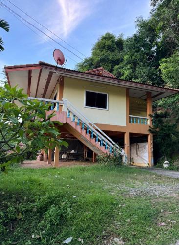 a house with a staircase on the side of it at Sea Dreamer Ao Yon Beach House in Ban Ao Makham