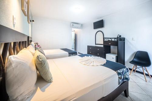 a bedroom with two beds and a desk and a chair at Paradise Jaco Beach Front in Jacó