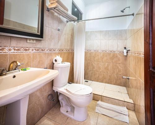 a bathroom with a toilet and a sink and a shower at Paradise Jaco Beach Front in Jacó