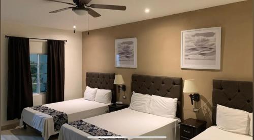 a hotel room with two beds and a ceiling fan at Hotel Plaza in Sabinas