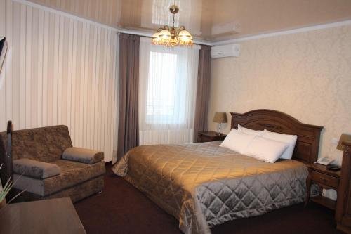 a hotel room with a bed and a chair at Aristokrat in Vinnytsya