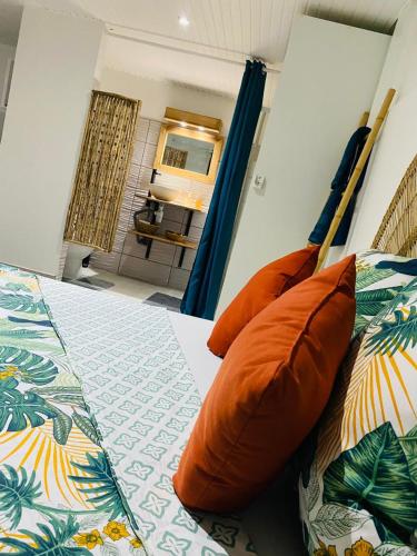 a bedroom with a bed with orange pillows on it at Bélya in Le Vauclin