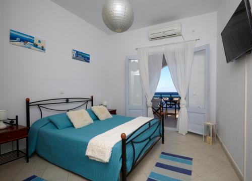 a bedroom with a bed and a view of the ocean at Rodothea and Adams on the Beach, Santorini in Monolithos