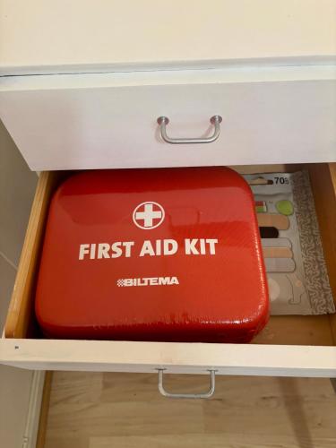 a red first aid kit sitting in a drawer at Linda`s house in Grashopen
