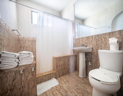 a bathroom with a toilet and a shower and a sink at Paradise Jaco Beach Front in Jacó