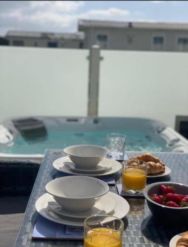 a table with plates of food and glasses of orange juice at Fantasy Island Holiday Park Eastgate - The Seasons with Hot Tub - Coastal Caravan Breaks in Ingoldmells
