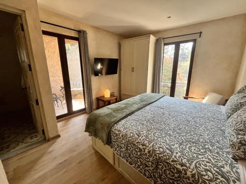 a bedroom with a bed and a sliding glass door at Val'quirico Auguri Zócalo II, Depto 5 Camas in Santeagueda