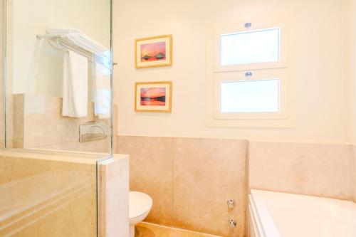 a bathroom with a tub and a toilet and a sink at Longchamps l Zamalek l Boutique Hotel with Breakfast in Cairo