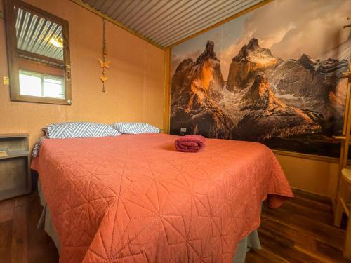 Un dormitorio con una cama con un cuadro en la pared. en Cabaña Aquiles, en Puerto Natales