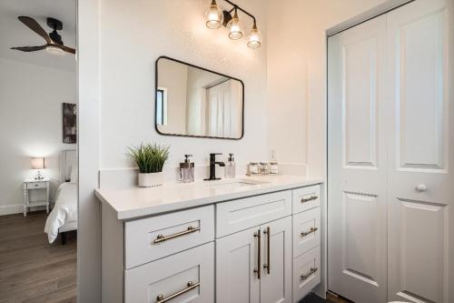 Un baño blanco con lavabo y espejo. en Luxury Downtown Oasis, Pool Table, Near Riverwalk, en San Antonio