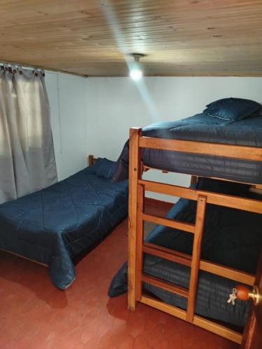 two bunk beds and a ladder in a room at Casa hotel, vía Duitama - pantano de Vargas in Tibasosa