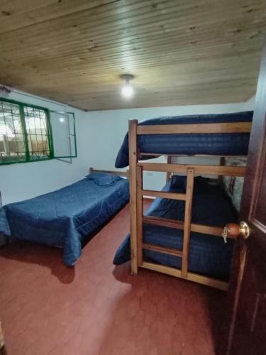 a room with two bunk beds and a window at Casa hotel, vía Duitama - pantano de Vargas in Tibasosa