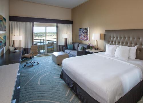 a hotel room with a large bed and a living room at Lakeway Resort & Spa in Lakeway