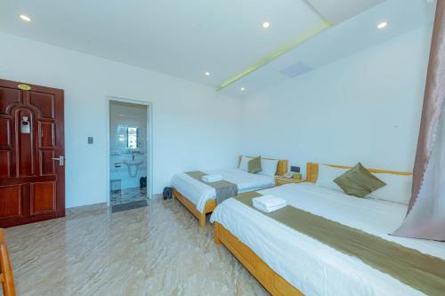 a bedroom with two beds and a mirror at Sunrise Valley Dalat Hotel in Da Lat
