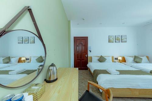 a room with two beds and a mirror on the wall at Sunrise Valley Dalat Hotel in Da Lat