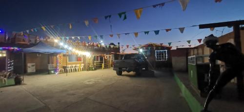a man walking down a street at night with flags at Salón y habitaciones in San Patricio
