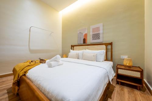 a bedroom with a large bed with white sheets at La Ferringhi Villa - Balinese Collection, by ALV in Batu Ferringhi