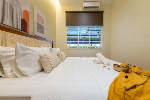 a bedroom with a large white bed with a stuffed animal on it at La Ferringhi Villa - Balinese Collection, by ALV in Batu Ferringhi