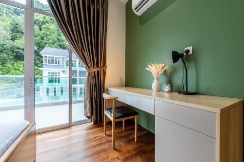 a bedroom with a desk and a window with a bed at La Ferringhi Villa - Balinese Collection, by ALV in Batu Ferringhi