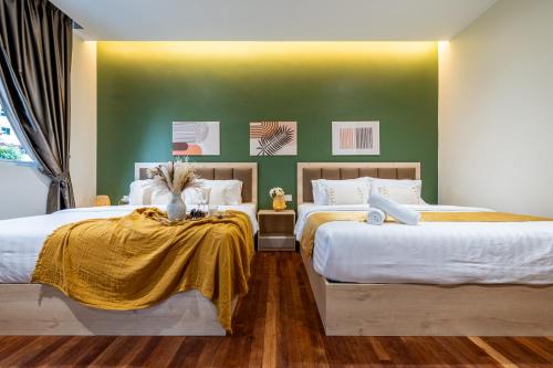 a bedroom with two beds and a green wall at La Ferringhi Villa - Balinese Collection, by ALV in Batu Ferringhi