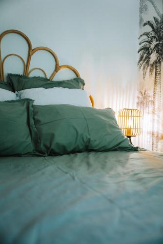 - un lit avec des oreillers verts et blancs dans l'établissement Cozy apartment in Saint-Tropez, à Saint-Tropez