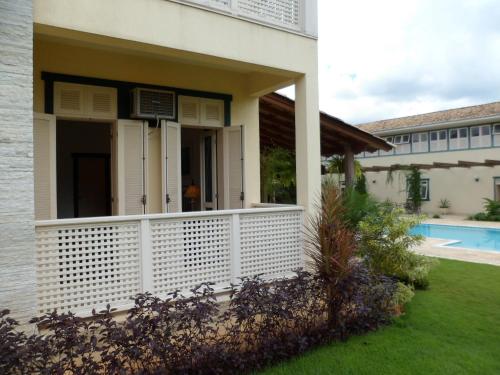 a house with a white porch and a pool at Don Quixote Pousada in Tiradentes