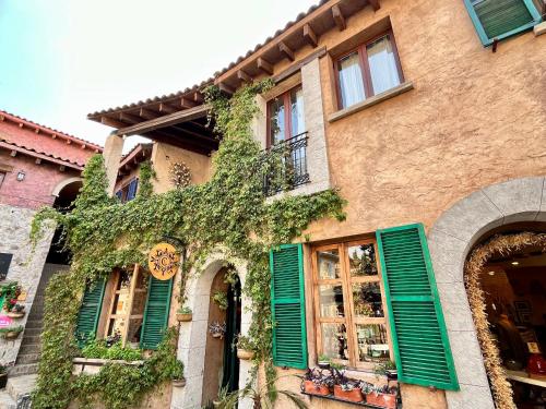 a building with green shutters and ivy on it at Val'quirico Auguri Zócalo II, Depto 5 Camas in Santeagueda