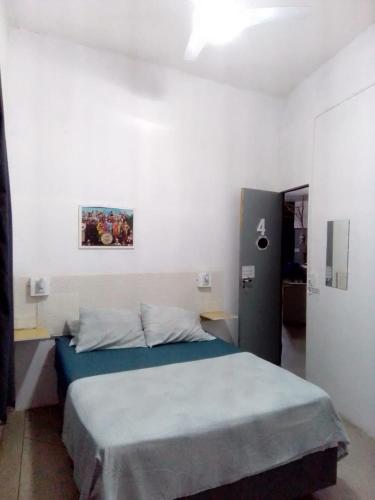 a bedroom with a bed in a white room at Hostel Lize in Cumbica