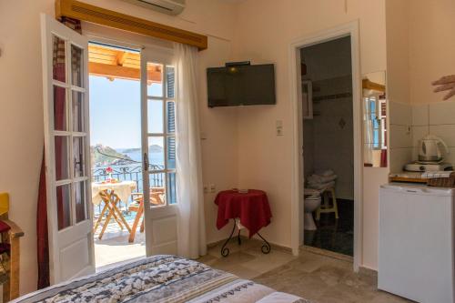 a room with a bed and a kitchen with a balcony at Melina's Sunset in Myrties