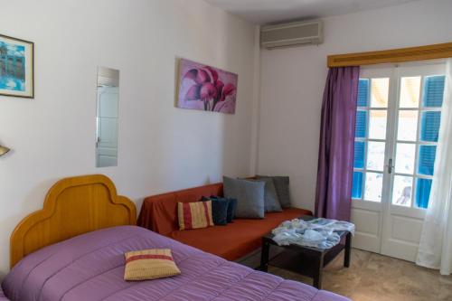 a bedroom with a bed and a couch and a window at Melina's Sunset in Myrties