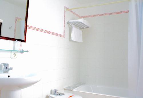 a white bathroom with a tub and a sink at Can Font in Sineu