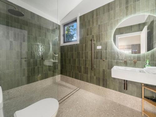 a bathroom with a toilet and a sink and a mirror at Birdsong Blackheath in Blackheath