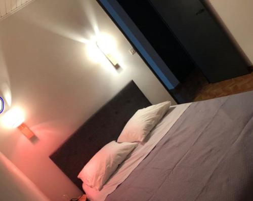 une chambre avec un lit avec deux oreillers dans l'établissement Maison au pied du lubéron, à Lauris