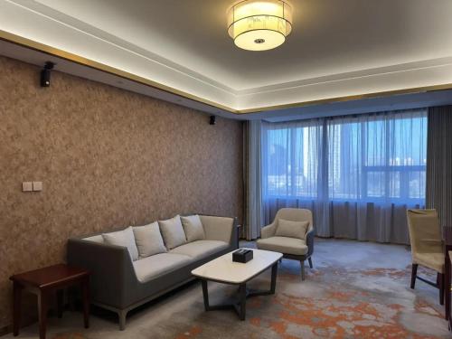 a living room with a couch and two chairs at Beijing Jingyi Hotel in Beijing