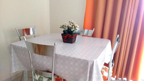 a white table with a vase of flowers on it at Prive das Thermas - 301B in Caldas Novas