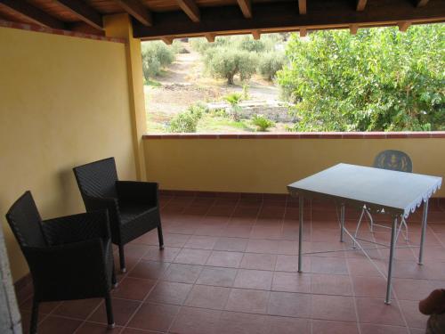 a table and chairs on a porch with a view of a field at Antica Tindari in Patti