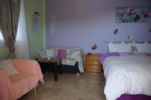 a bedroom with two beds and a couch at Melina's Sunset in Myrties