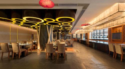 a restaurant with a dining room with tables and chairs at Regal Palace Hotel in Dongguan