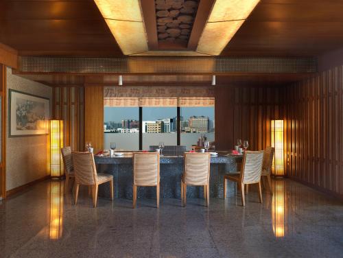 a dining room with chairs and a bar with a view at Regal Palace Hotel in Dongguan